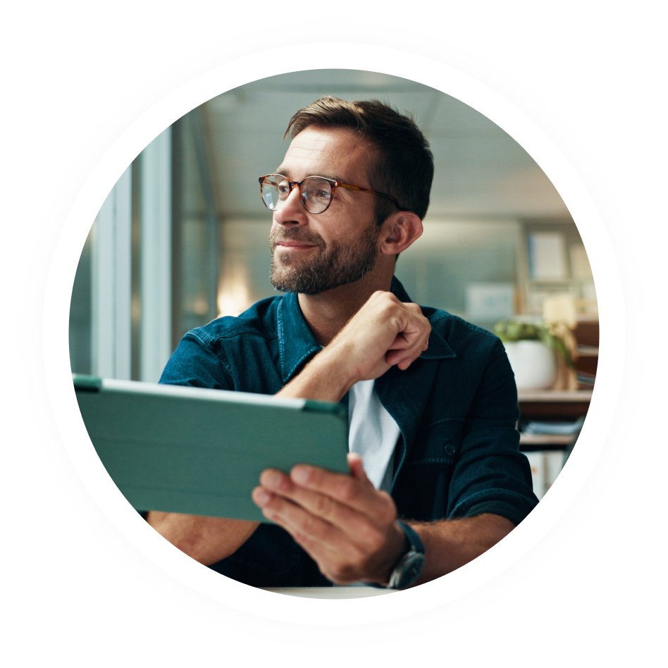 A man wearing glasses holding a tablet